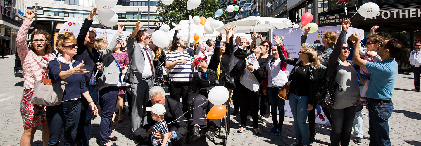 A group of persons with balloons.